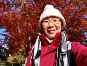 Chinese woman smiling in a beanie and red jacket